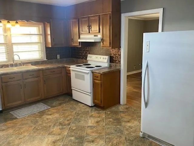 a kitchen with a stove a refrigerator and a sink
