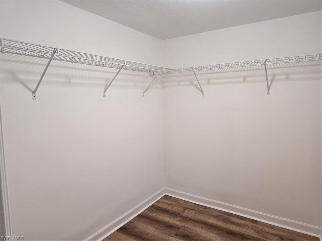 5737 Whitaker Road, Unit C104 Naples, FL 34112 - Photo 27 of 35 Walk-in closet with white wire shelving and wood-finish flooring