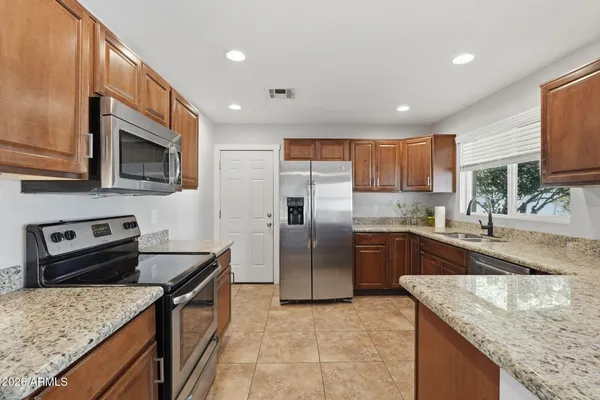 a kitchen with stainless steel appliances granite countertop a sink stove microwave and refrigerator