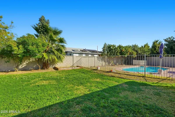 a view of a backyard with swimming pool and seating space