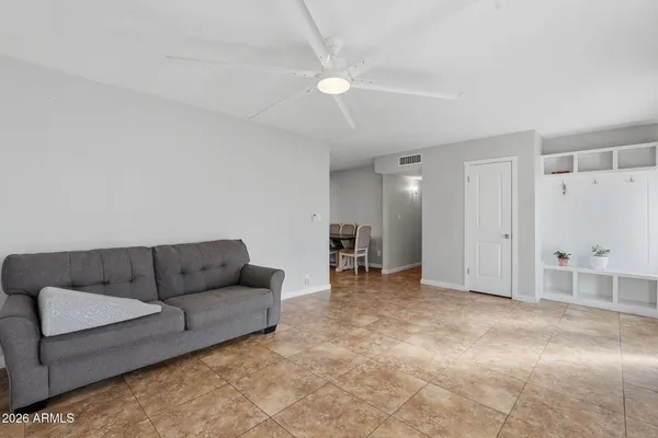 a living room with furniture and a ceiling fan