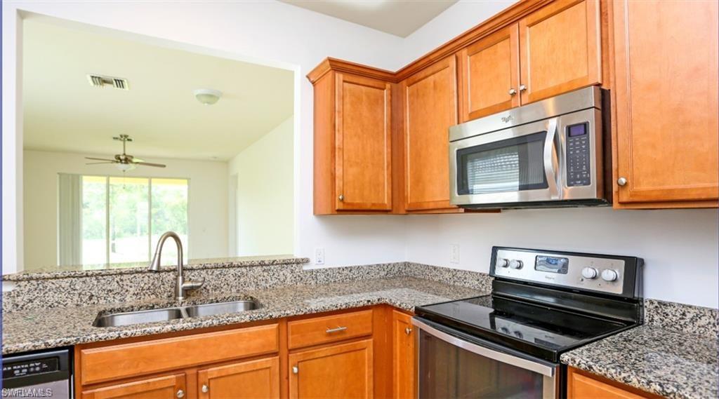 8482 Karina Court Naples, FL 34114 - Photo 11 of 40 a kitchen with stainless steel appliances granite countertop a sink and cabinets