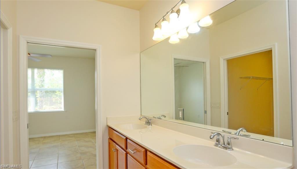 8482 Karina Court Naples, FL 34114 - Photo 15 of 40 a bathroom with a granite countertop sink and a mirror