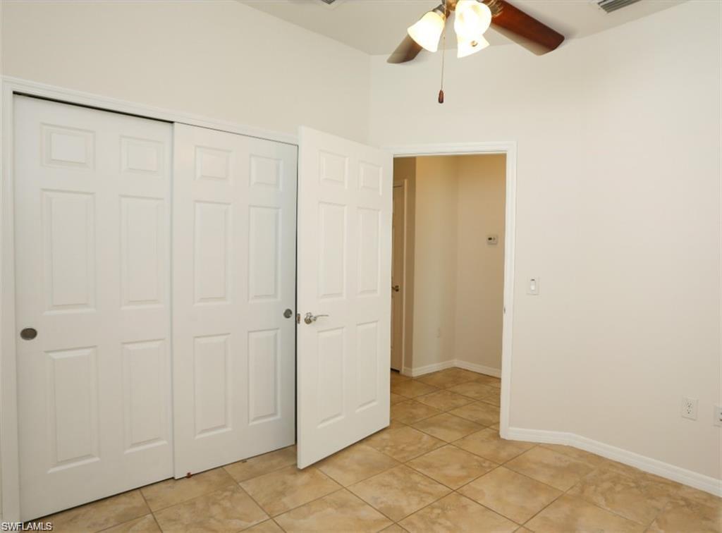 8482 Karina Court Naples, FL 34114 - Photo 17 of 40 a view of a room with a chandelier fan