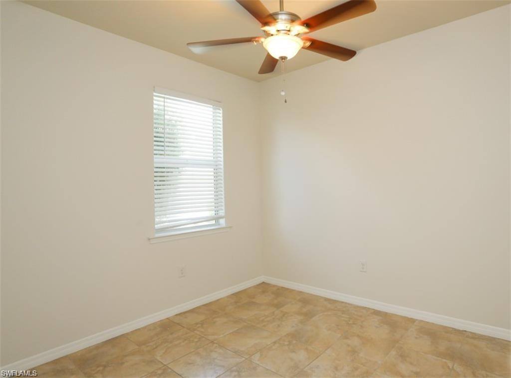 8482 Karina Court Naples, FL 34114 - Photo 18 of 40 an empty room with a window and a fan