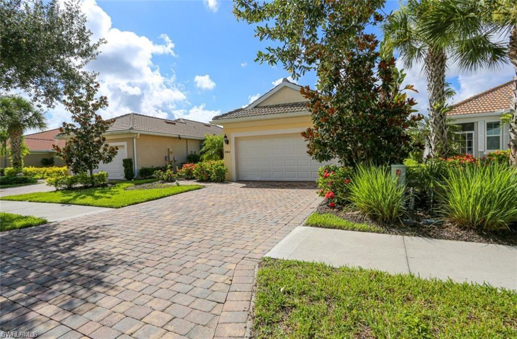 8482 Karina Court Naples, FL 34114 - Photo 2 of 40 a front view of a house with a yard and garage