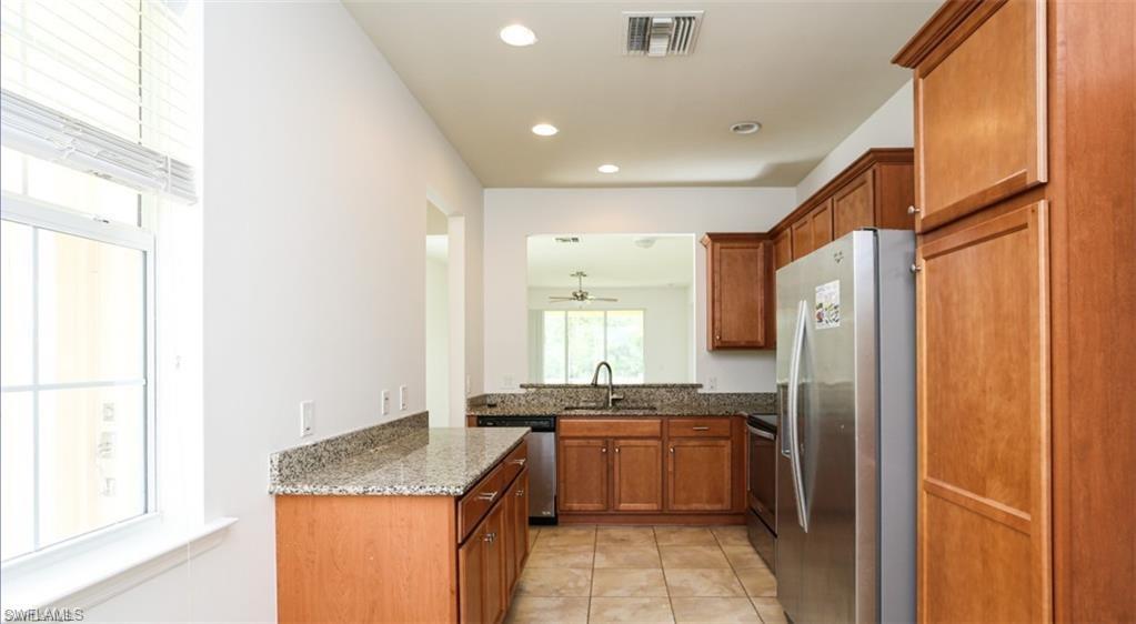 8482 Karina Court Naples, FL 34114 - Photo 8 of 40 a kitchen with granite countertop a refrigerator and a sink