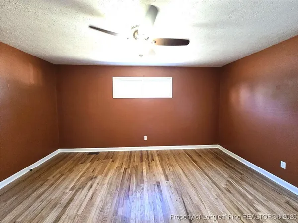 a view of a big room with wooden floor and windows