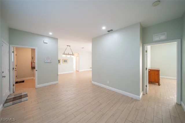 a view of a hallway with wooden floor and a bathroom