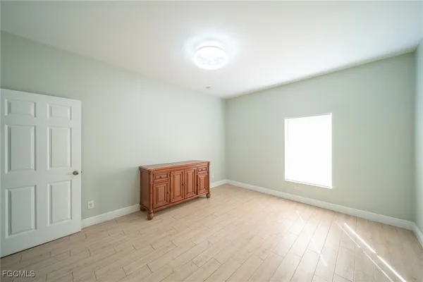 an empty room with windows and cabinet