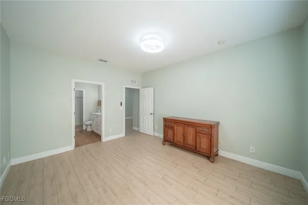 an empty room with a window and wooden floor