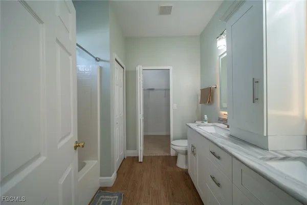 a spacious bathroom with a double vanity sink a mirror and a shower
