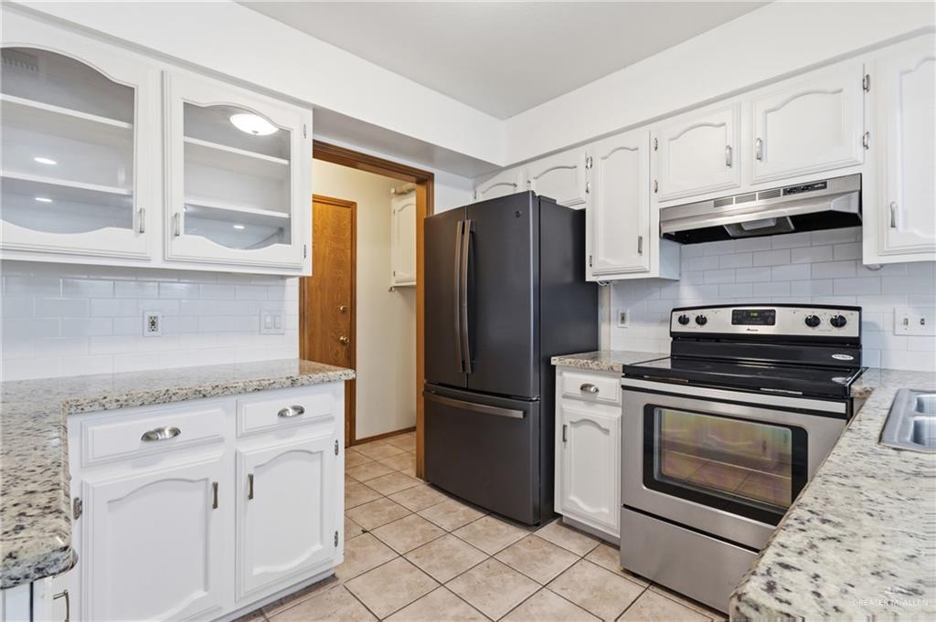 2312 Yarrow Street Mission, TX 78574 - Photo 3 of 20 a kitchen with granite countertop white cabinets and stainless steel appliances