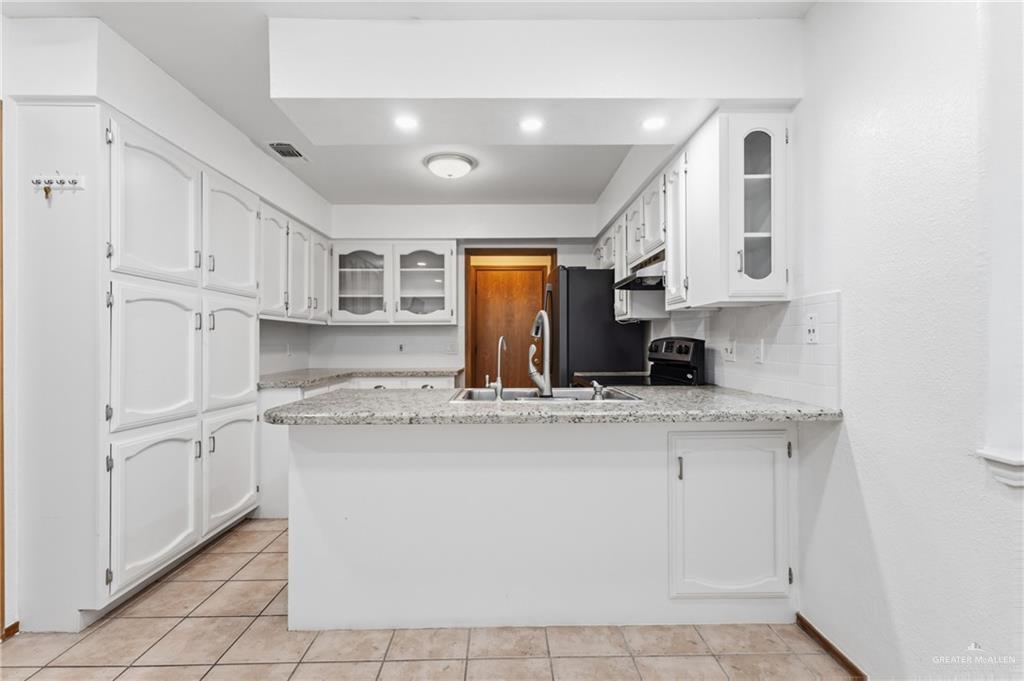 2312 Yarrow Street Mission, TX 78574 - Photo 4 of 20 a kitchen with stainless steel appliances granite countertop a stove a sink and a refrigerator