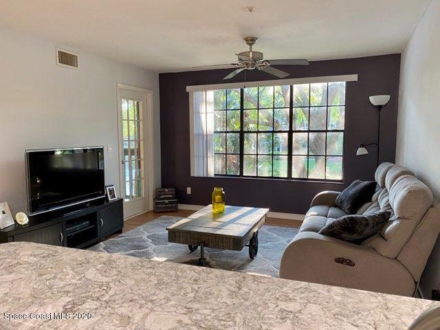 7667 North Wickham Road, Unit 214 Melbourne, FL 32940 - Photo 3 of 16 a living room with furniture and a flat screen tv