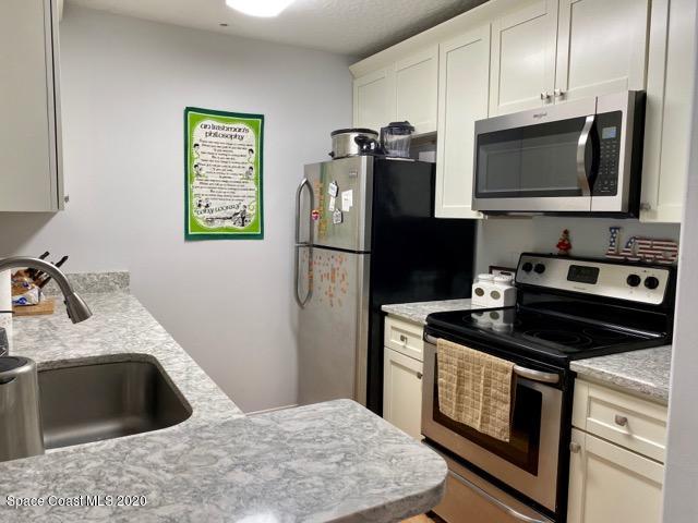 7667 North Wickham Road, Unit 214 Melbourne, FL 32940 - Photo 5 of 16 a kitchen with a stove microwave and refrigerator