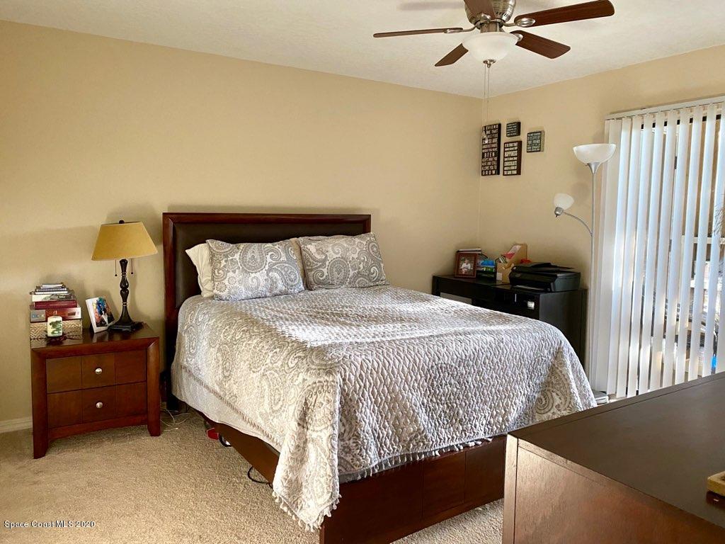7667 North Wickham Road, Unit 214 Melbourne, FL 32940 - Photo 7 of 16 a bedroom with a bed and a chandelier