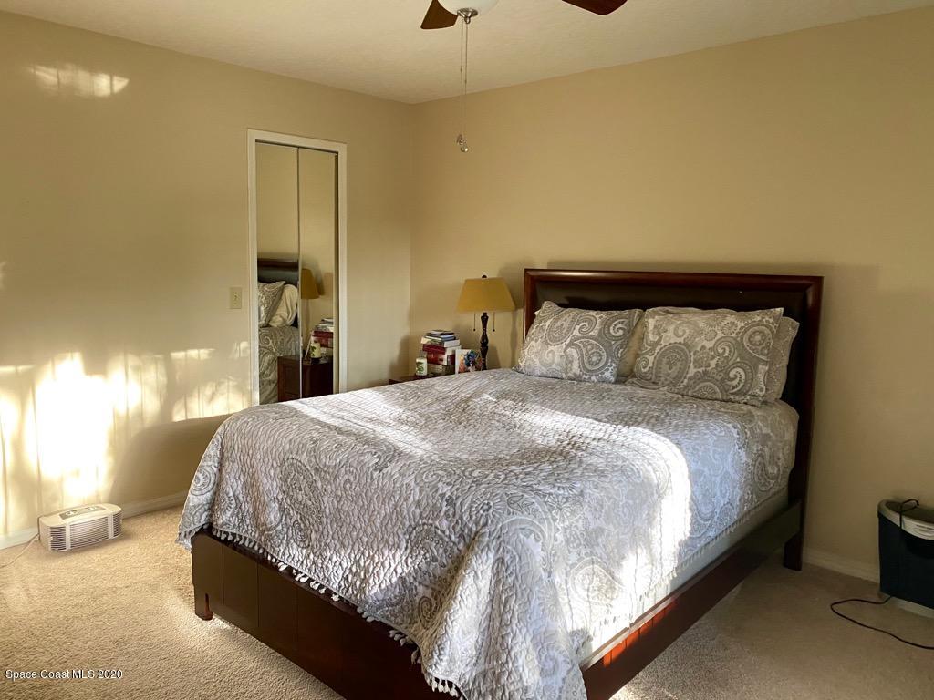 7667 North Wickham Road, Unit 214 Melbourne, FL 32940 - Photo 8 of 16 a large bed sitting in a bedroom next to a lamp