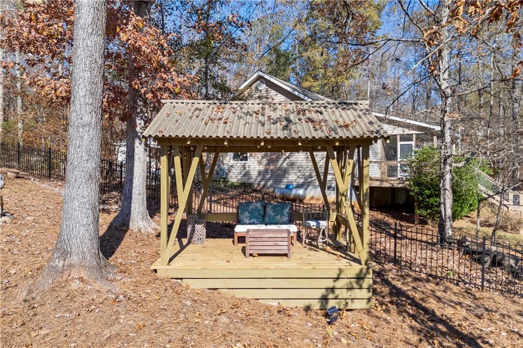 243 Bluegill Road Eatonton, GA 31024 - Photo 121 of 136 a view of a patio with table and chairs potted plants and large tree