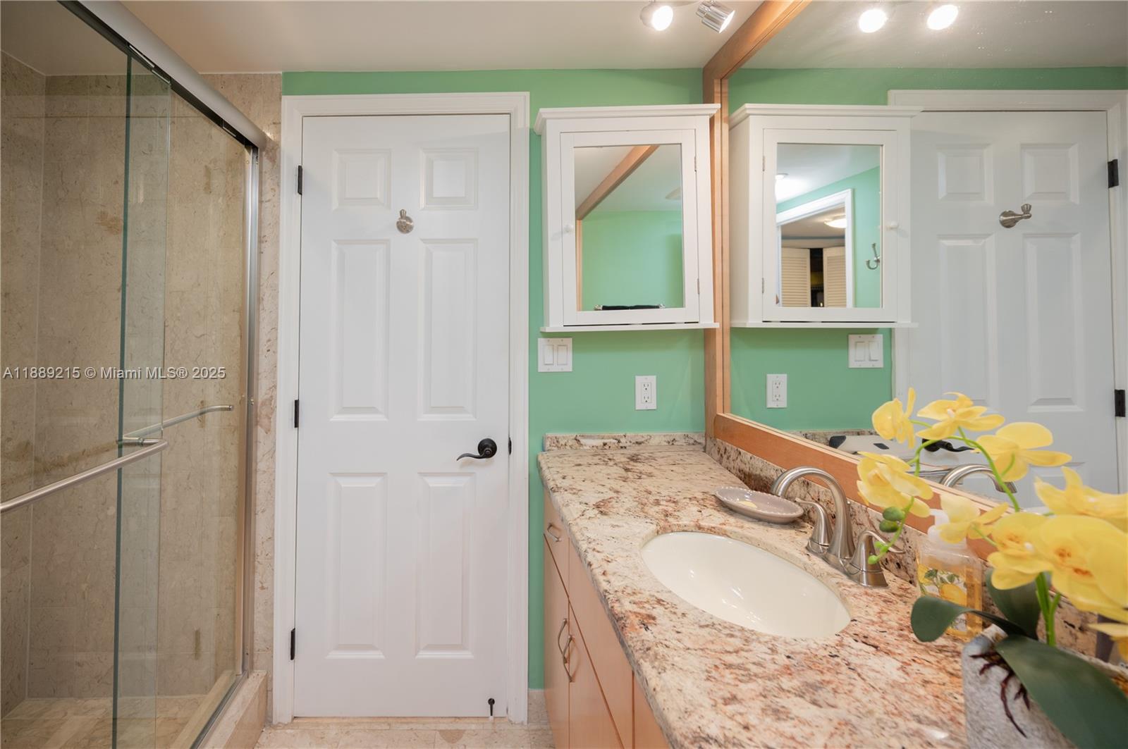 3 Grove Isle Drive, Unit C308 Miami, FL 33133 - Photo 11 of 54 a bathroom with a granite countertop sink and a mirror
