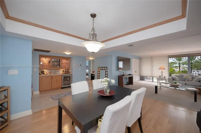a view of a dining room and livingroom with furniture wooden floor a chandelier
