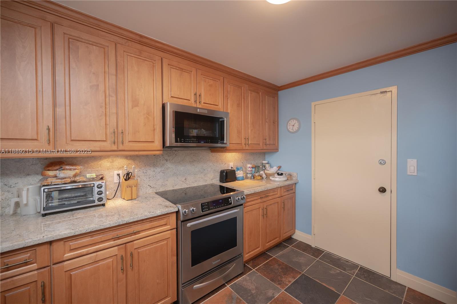 3 Grove Isle Drive, Unit C308 Miami, FL 33133 - Photo 6 of 54 a kitchen with granite countertop a sink a stove top oven and cabinetry