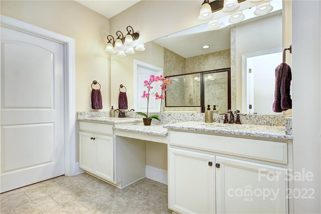 905 Ospre Lane Fort Mill, SC 29708 - Photo 14 of 35 a bathroom with a granite countertop sink a large mirror and a shower