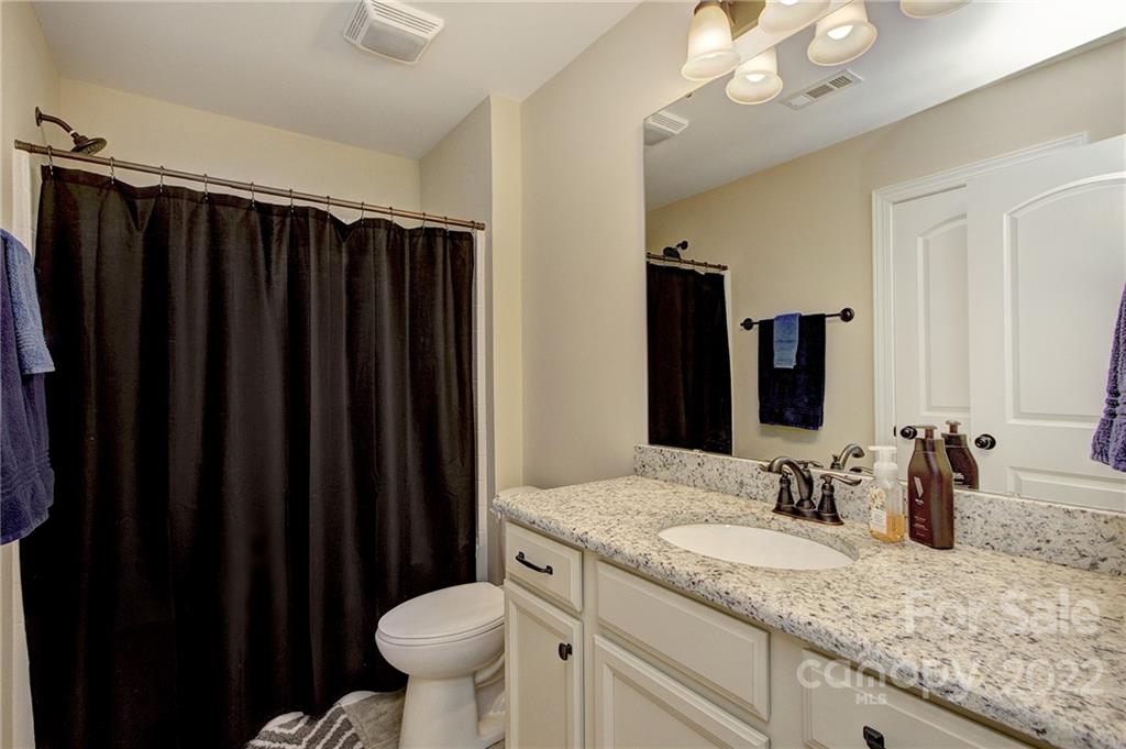 905 Ospre Lane Fort Mill, SC 29708 - Photo 19 of 35 a bathroom with a granite countertop sink a toilet a mirror and shower curtain