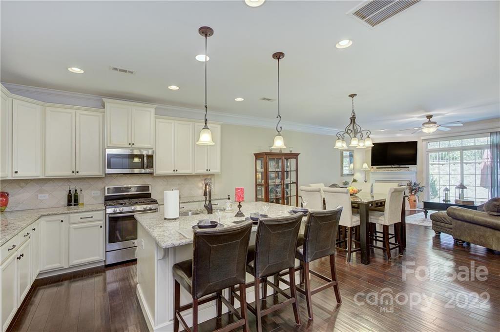905 Ospre Lane Fort Mill, SC 29708 - Photo 5 of 35 a open dining room with stainless steel appliances kitchen island granite countertop a table chairs and a view of living room