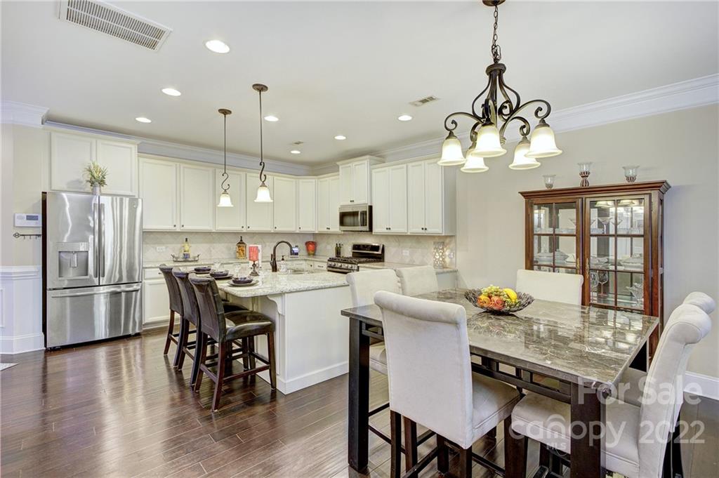 905 Ospre Lane Fort Mill, SC 29708 - Photo 6 of 35 a kitchen with stainless steel appliances a dining table chairs stove refrigerator and microwave