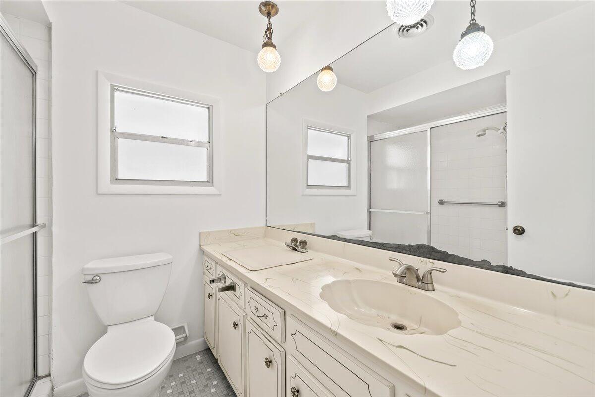 2862 Starlight Circle Northeast Palm Bay, FL 32905 - Photo 21 of 45 a bathroom with a toilet sink a mirror and vanity