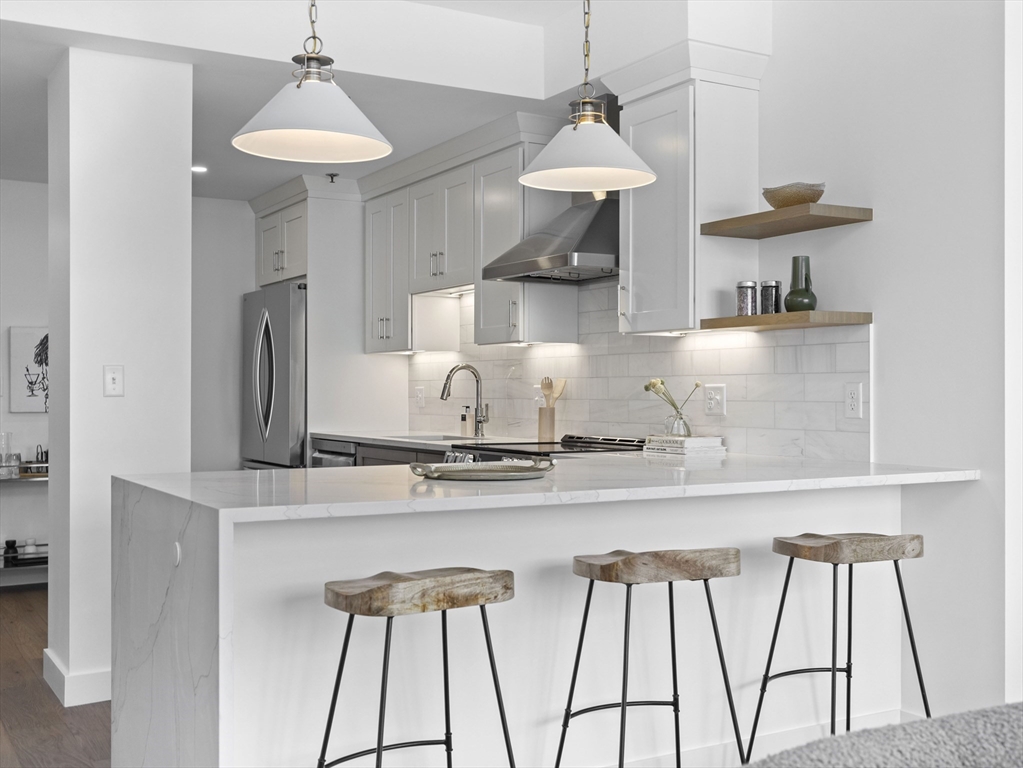 a kitchen with stainless steel appliances granite countertop a sink a stove and a refrigerator