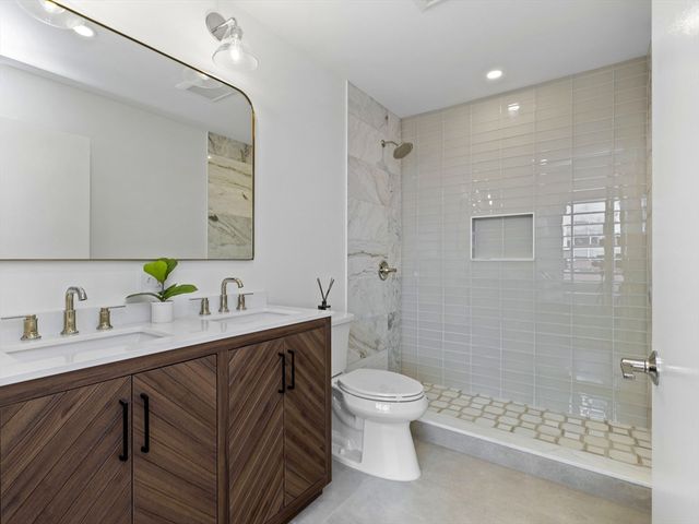 a bathroom with a sink a toilet and shower