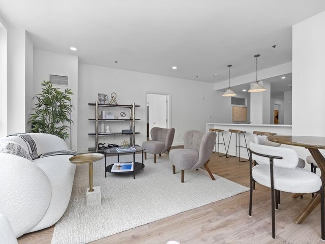 a living room with furniture and a wooden floor