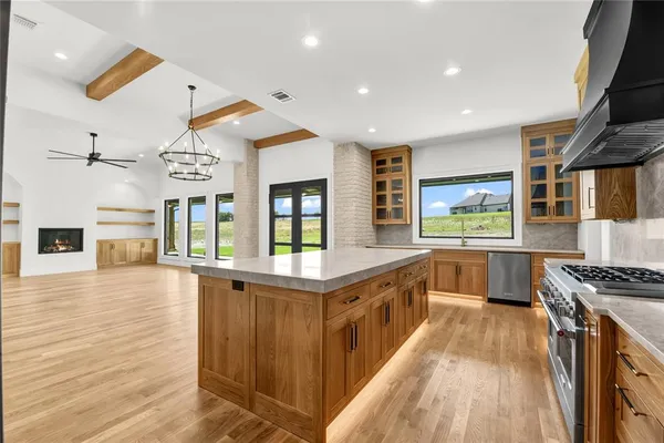 a kitchen with stainless steel appliances granite countertop a stove and a large refrigerator