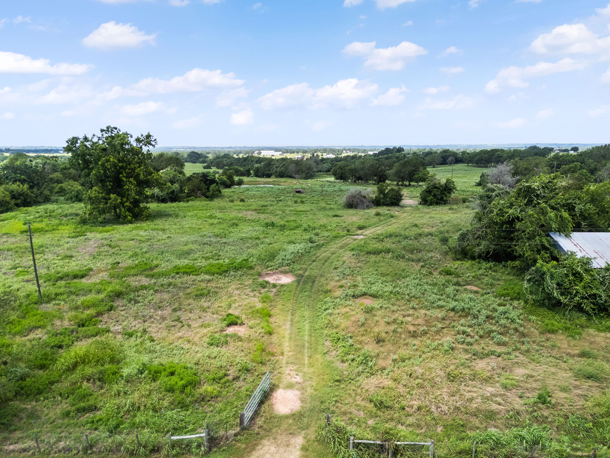 0 Thielemann Road Industry, TX 78944 - Photo 10 of 40 Vast green acres stretch under a bright sky, offering limitless possibilities for development.