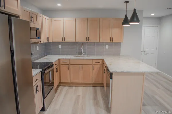a kitchen with a sink a stove a refrigerator and cabinets