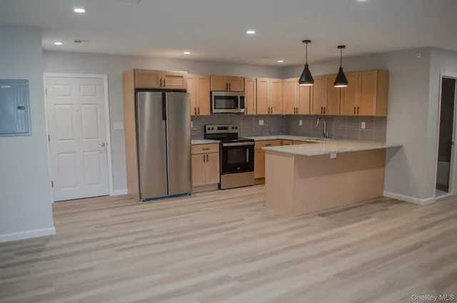 a large kitchen with stainless steel appliances granite countertop a stove and a refrigerator