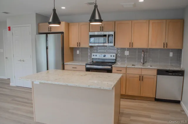 a kitchen with granite countertop a sink stainless steel appliances and cabinets