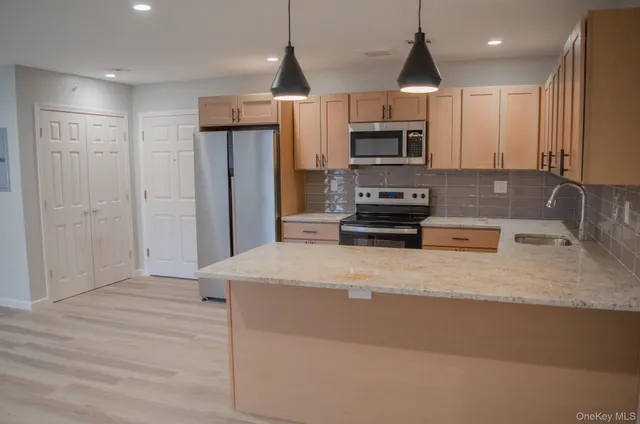 a kitchen with stainless steel appliances granite countertop a stove a refrigerator and a sink