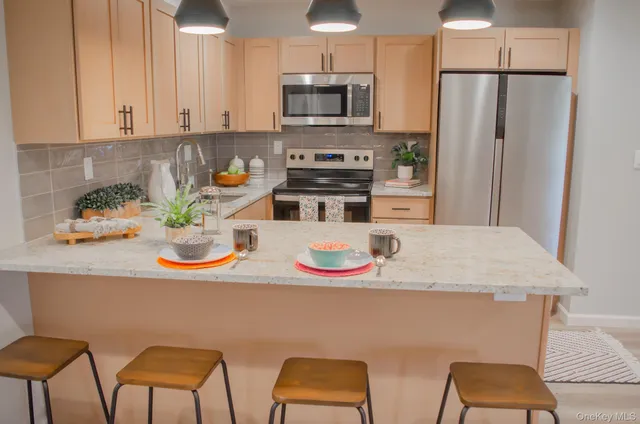 a kitchen with stainless steel appliances granite countertop a sink and a refrigerator