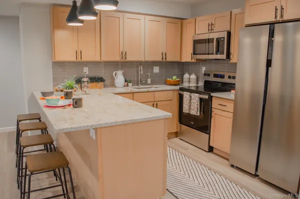 a kitchen with stainless steel appliances a stove a sink and a refrigerator