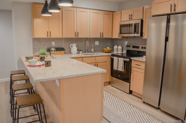 a kitchen with stainless steel appliances a stove a sink and a refrigerator
