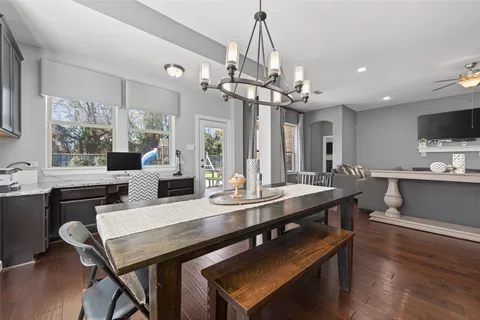 a view of a dining room and livingroom with furniture wooden floor a chandelier