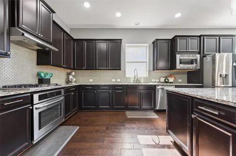 a kitchen with stainless steel appliances granite countertop a stove sink and cabinets