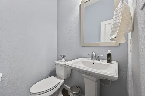 a bathroom with a sink a toilet and mirror