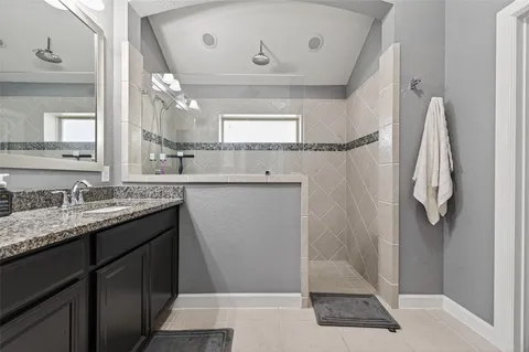 a bathroom with a granite countertop sink a mirror and a shower