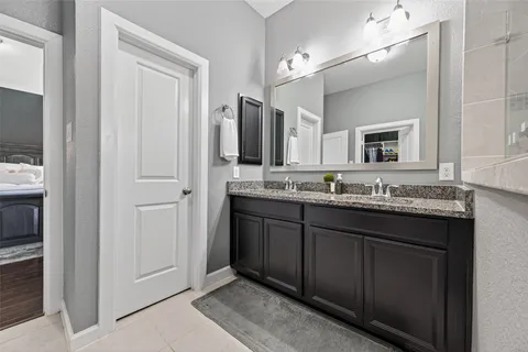 a bathroom with a granite countertop sink and a mirror