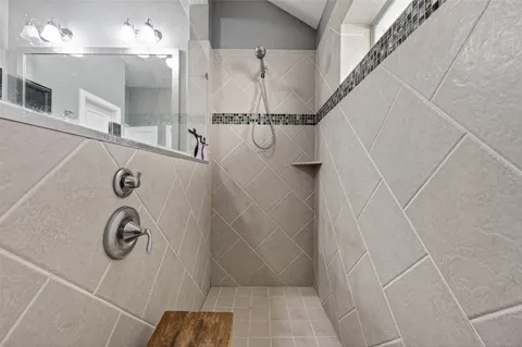 a bathroom with shower and mirror