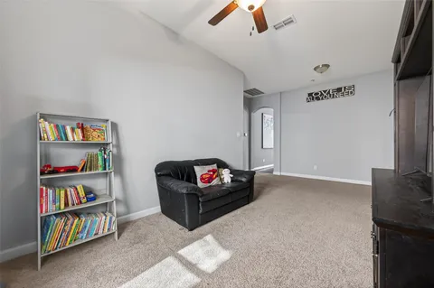 a living room with furniture and a book shelf